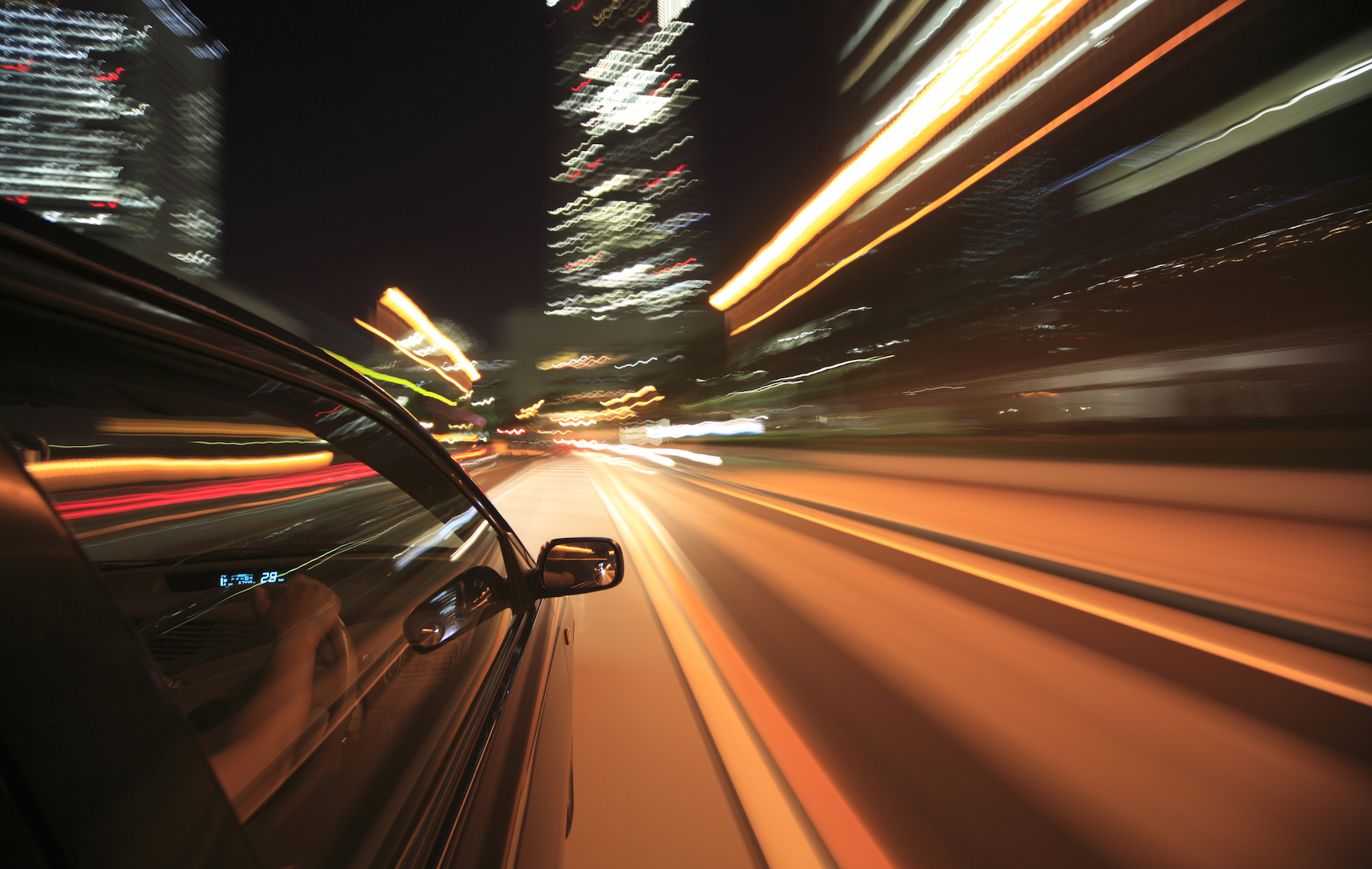 Exterior of a car driving at night through the city